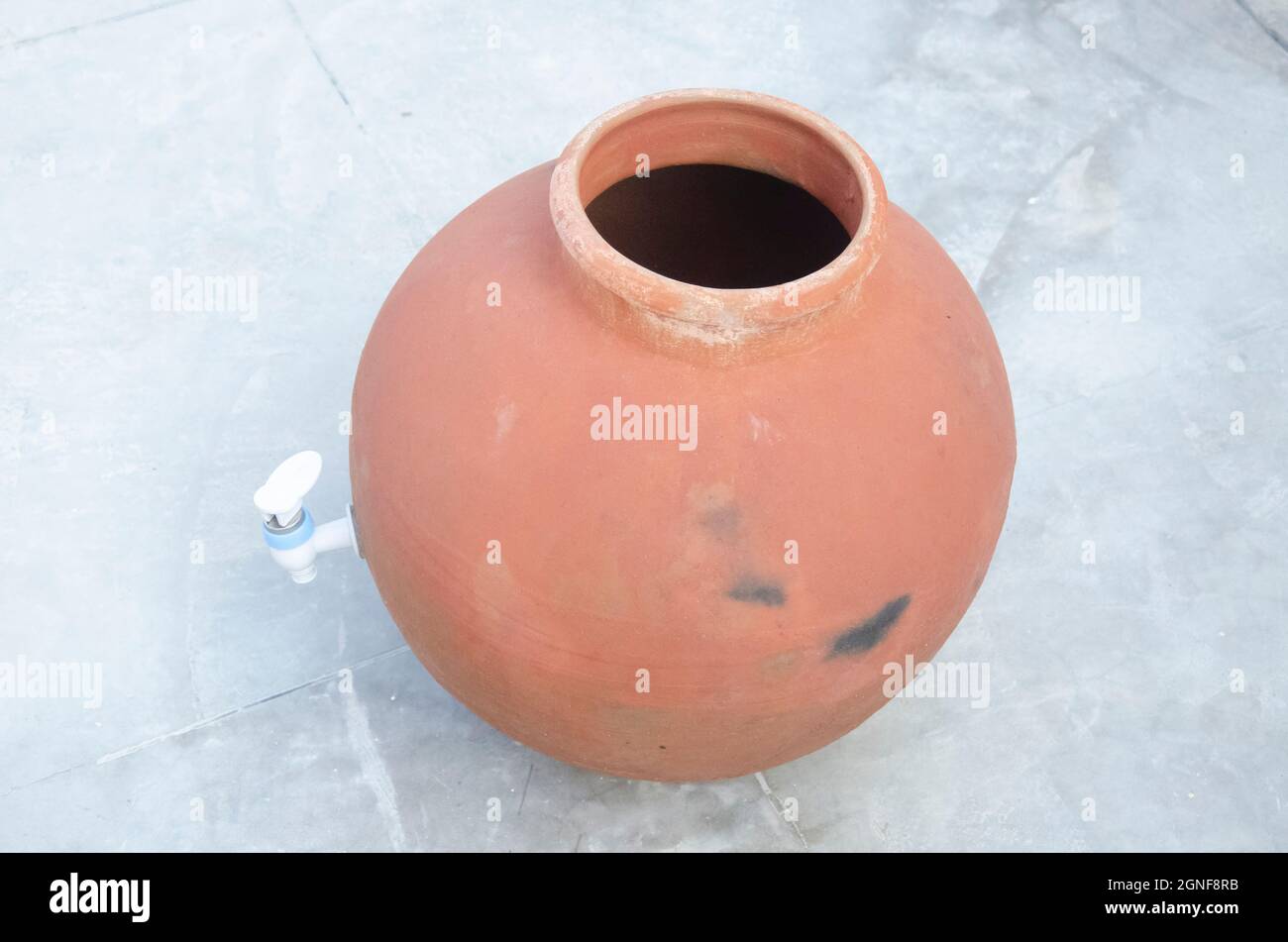 Selective focus on CLAY PITCHER WITH PLASTIC TAP. Handmade indian craft
