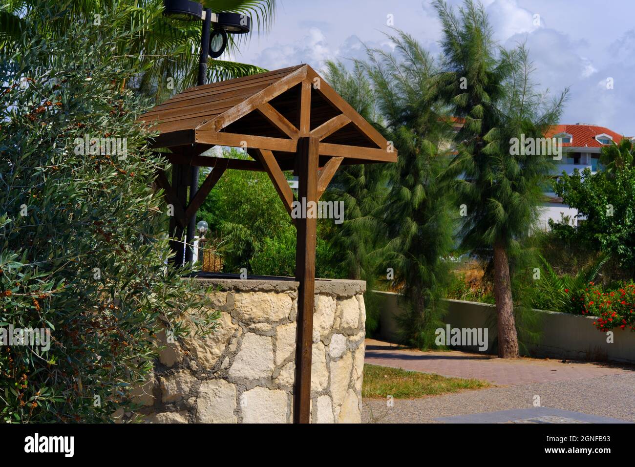 Vintage Dry Water Well on Street withing Trees at a Sunny Summer day outdoor Stock Photo