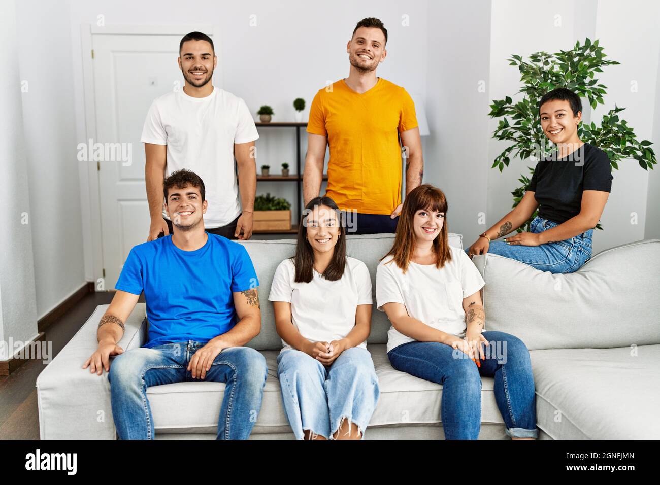 Group of young friends smiling happy sitting on the sofa at home Stock ...