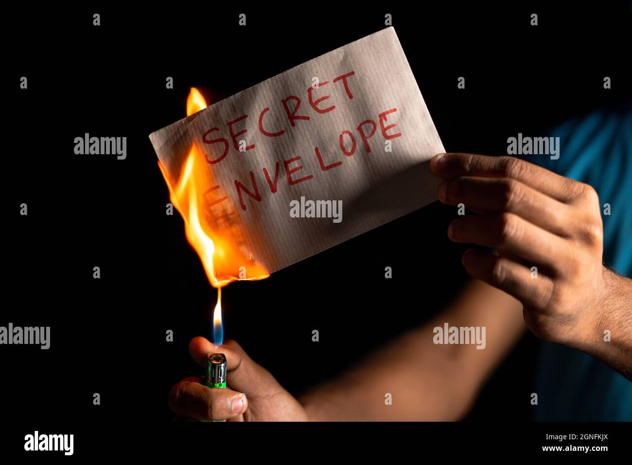 closeup shot of hands burning top-secret document or envelope - concept of illegally destroying evidence and erasing documents. Stock Photo