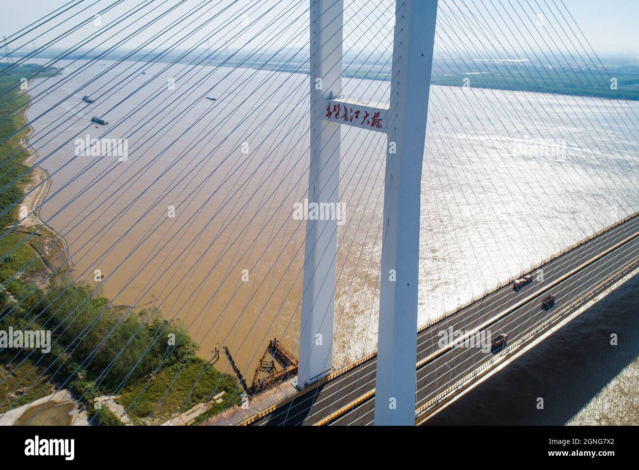 (210925) -- WUHAN, Sept. 25, 2021 (Xinhua) -- Aerial photo taken on Sept. 25, 2021 shows the Chibi Yangtze River road bridge in central China's Hubei Province. Two new bridges over the Yangtze River opened to traffic Saturday in central China's Hubei Province. With a total length of 31 km and an 808-meter-long main span, the Wuxue Yangtze River road bridge links Wuxue City with Yangxin County of Huangshi City. The bridge has six lanes with a designed speed of 100 kph. The 11.2-km Chibi Yangtze River road bridge, with a 720-meter-long main span, shortened the vehicular travel time between Chibi Stock Photo