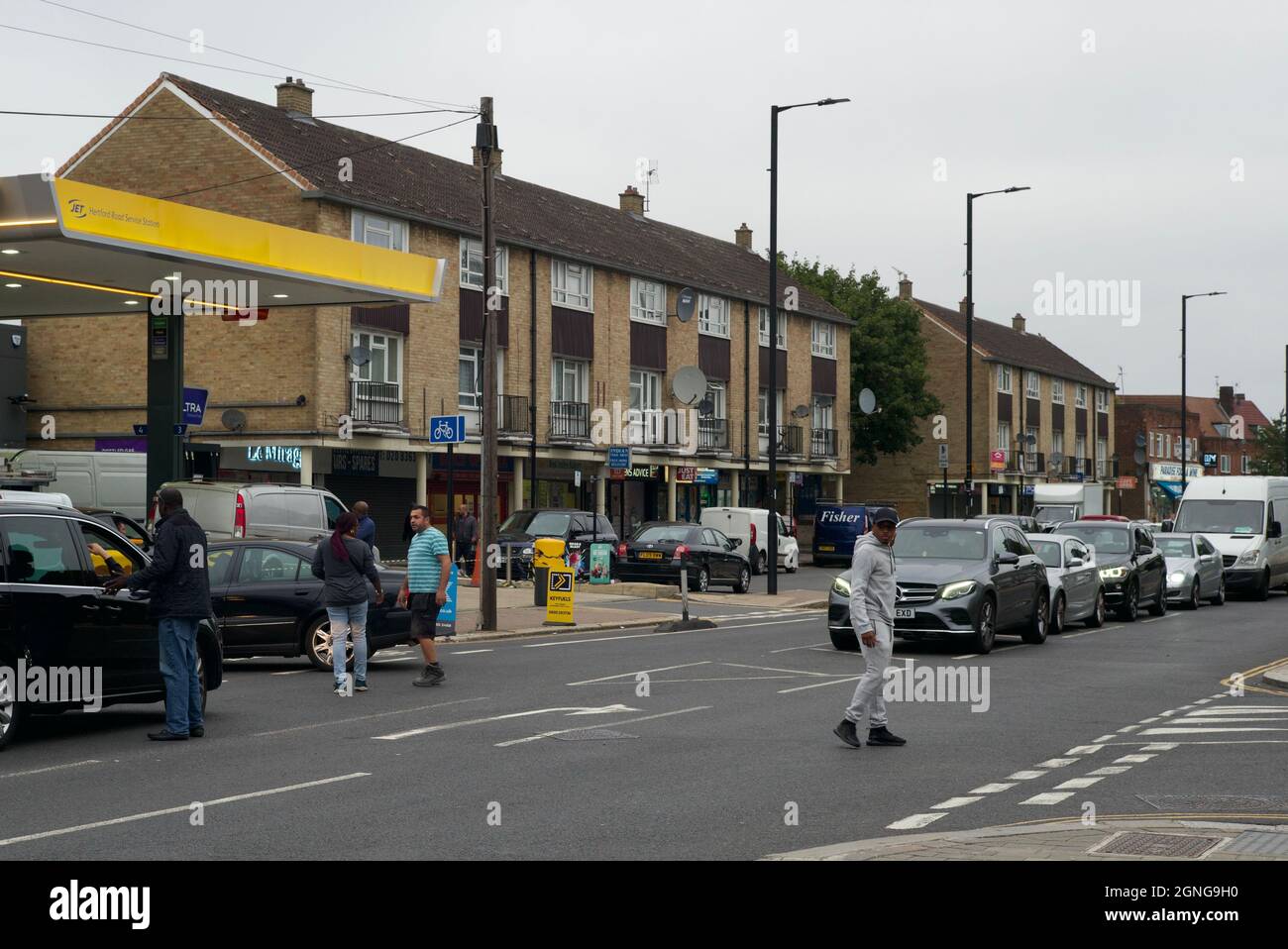 Enfield, UK. 25th September 2021. Long queues forming outside a petrol station in Enfield. Some people had got out of cars to try direct traffic. One petrol had closed in area. Andrew Steven Graham/Alamy Live News Stock Photo