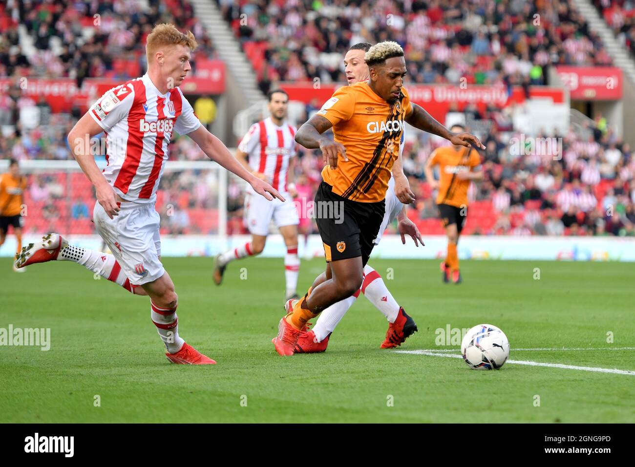 Hull City's Mallik Wilks is challenged by Stoke City's James Chester (hidden) during the Sky Bet Championship match at the bet365 Stadium, Stoke. Picture date: Saturday September 25, 2021. Stock Photo