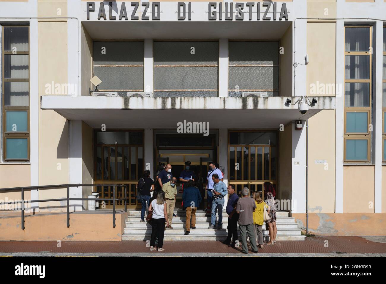 Locri, Italy. 25th Sep, 2021. People are seen waiting outside Locri's courthouse.The pro-migrant former Mayor of Riace, Domenico “Mimmo” Lucano, arrived at Locri's courthouse for the defensive conclusive statements of the trial for illegal immigration charges. The final session of the trial has been scheduled for September 27, 2021. Lucano is also running for upcoming regional elections with the list “Un'altra Calabria è possibile”. (Photo by Valeria Ferraro/SOPA Images/Sipa USA) Credit: Sipa USA/Alamy Live News Stock Photo