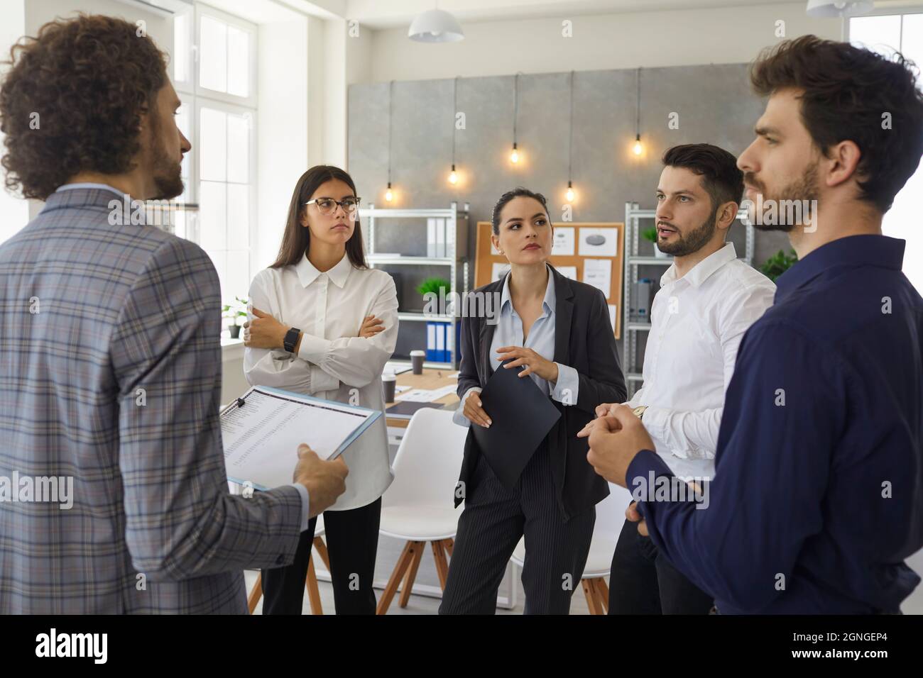 Serious people colleagues in the office discuss and plan a business plan for a new future project. Stock Photo