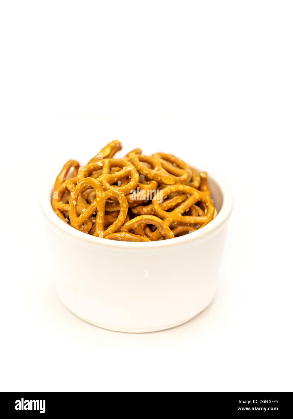 Salted mini pretzel snacks in white bowl isolated on white background Stock Photo