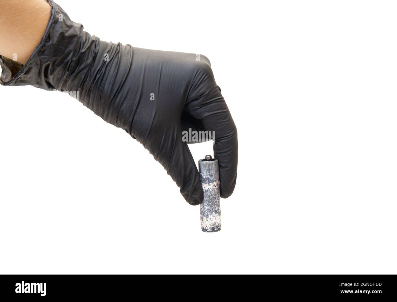 Heavily corroded AA type battery in black gloved hand isolated on white