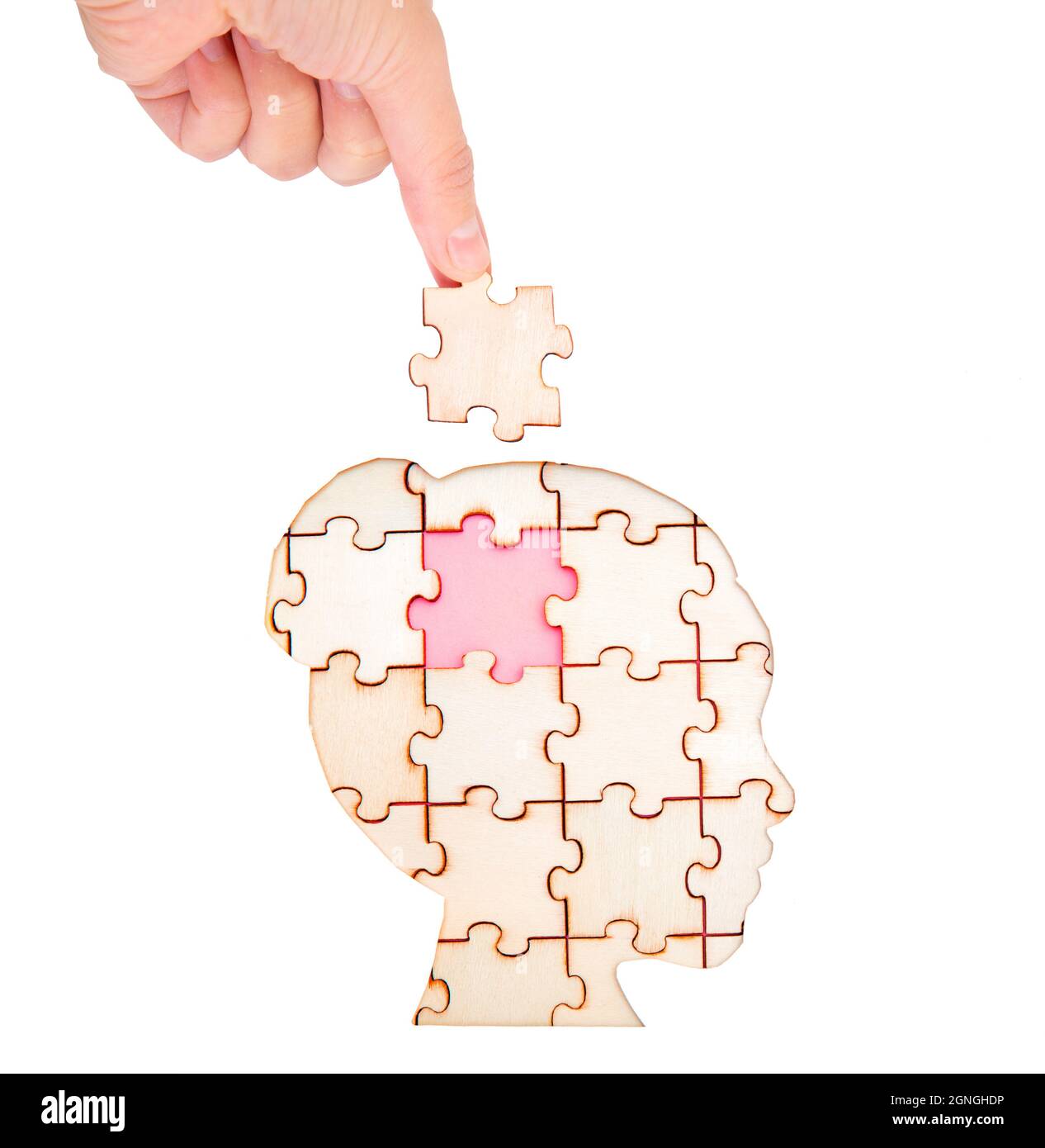 Placing the missing brain piece of the jigsaw puzzle forming a woman's head isolated on white. Psychotherapy concept. Stock Photo
