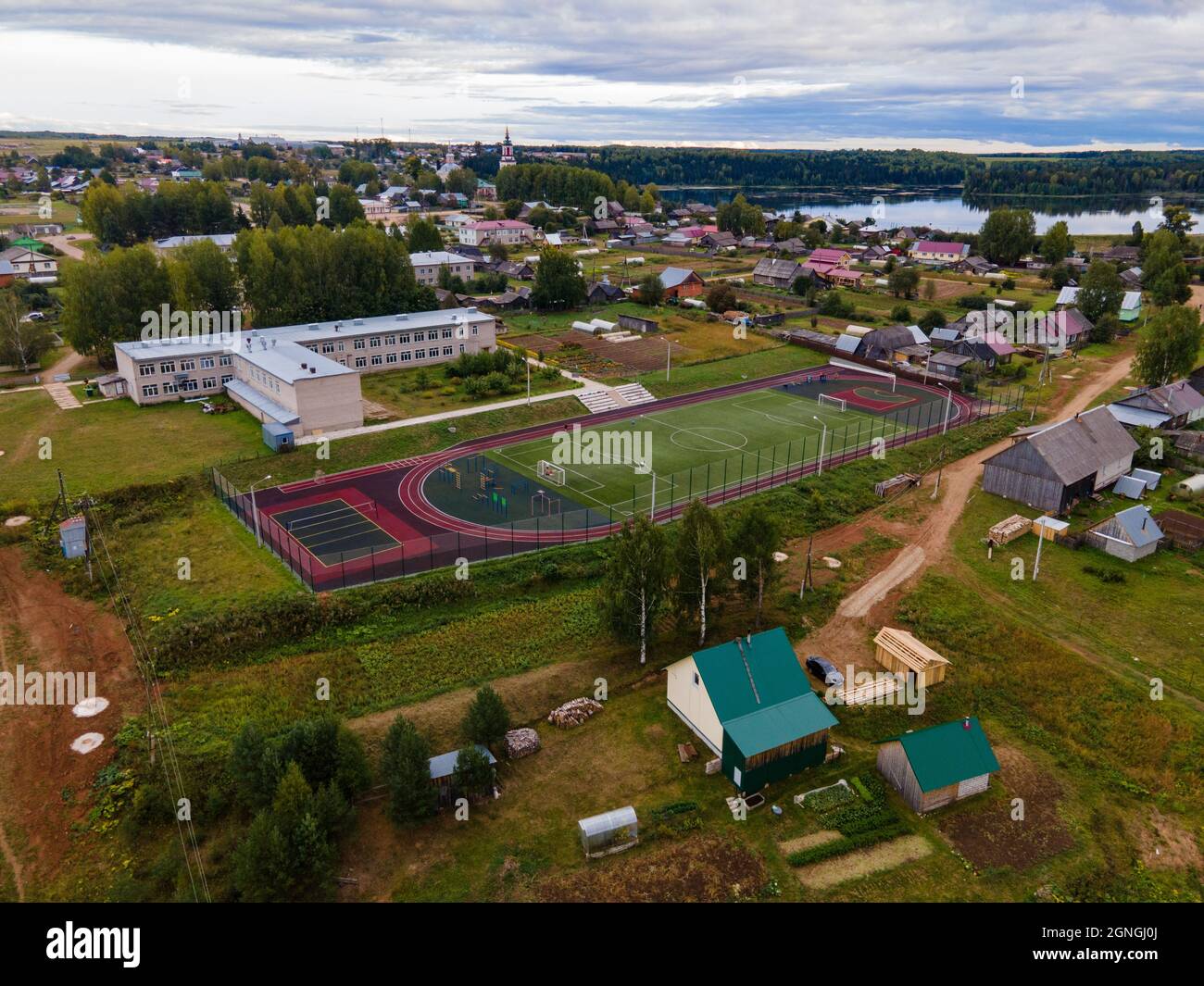Houses and football field against river in suburb Stock Photo