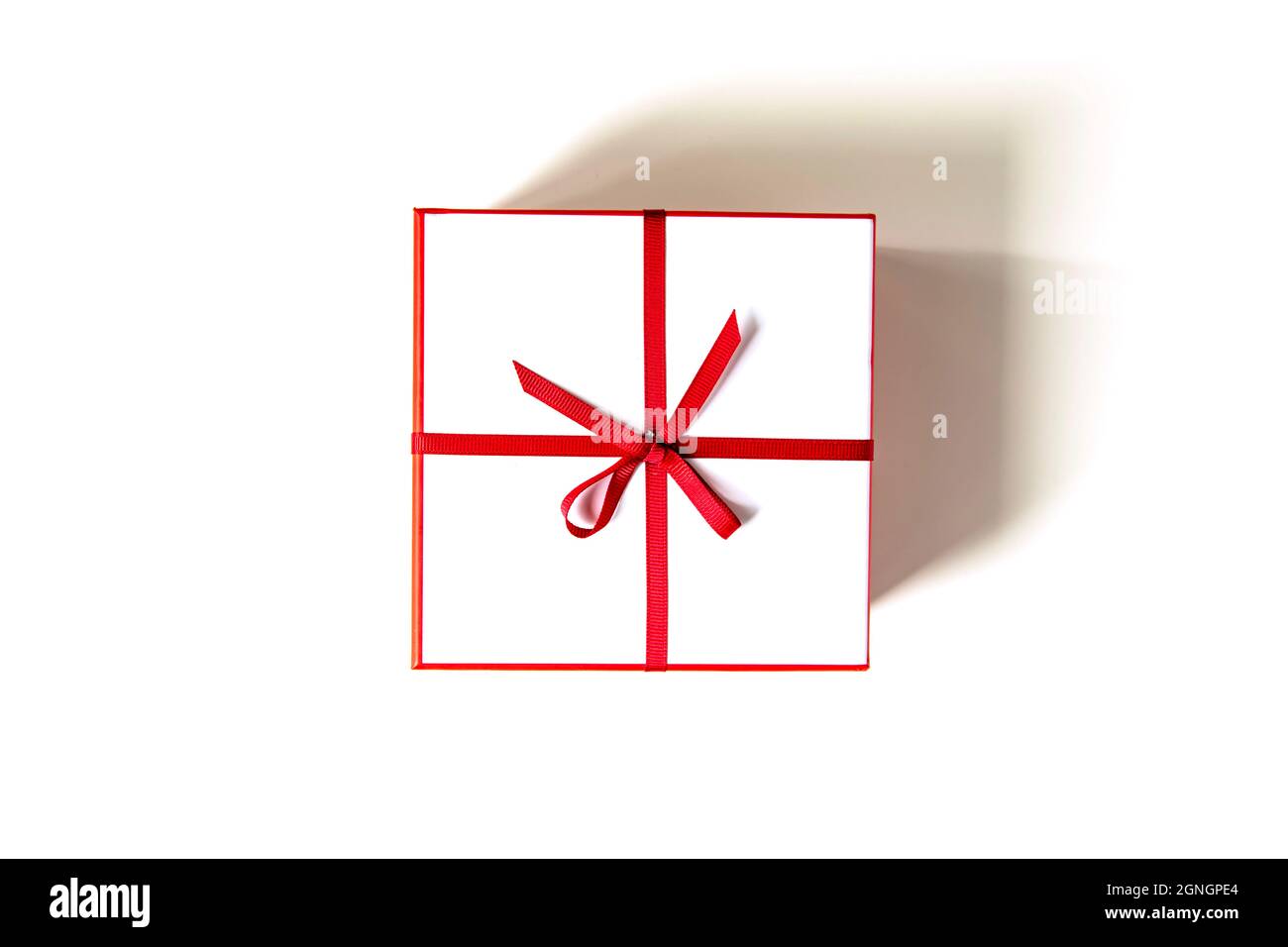 Gift white box with red ribbon and bow isolated on white. View from ...