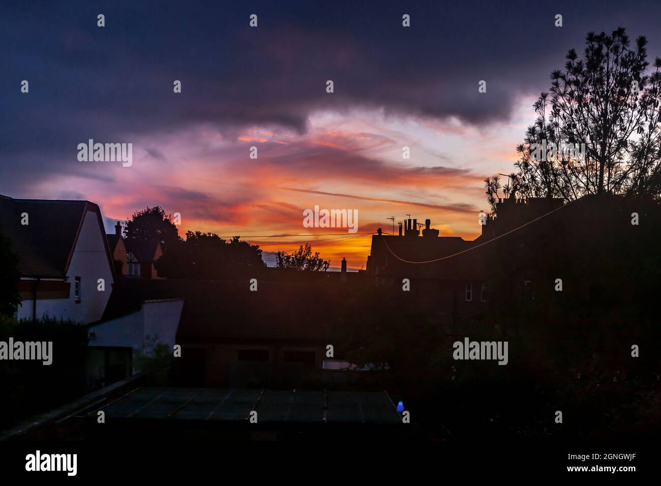 Northampton, UK. Weather. 25th September 2021. Colourful sky looking westward over the rooftops as the sun drops out of sight after a nice day, Credit: Keith J Smith./Alamy Live News. Stock Photo