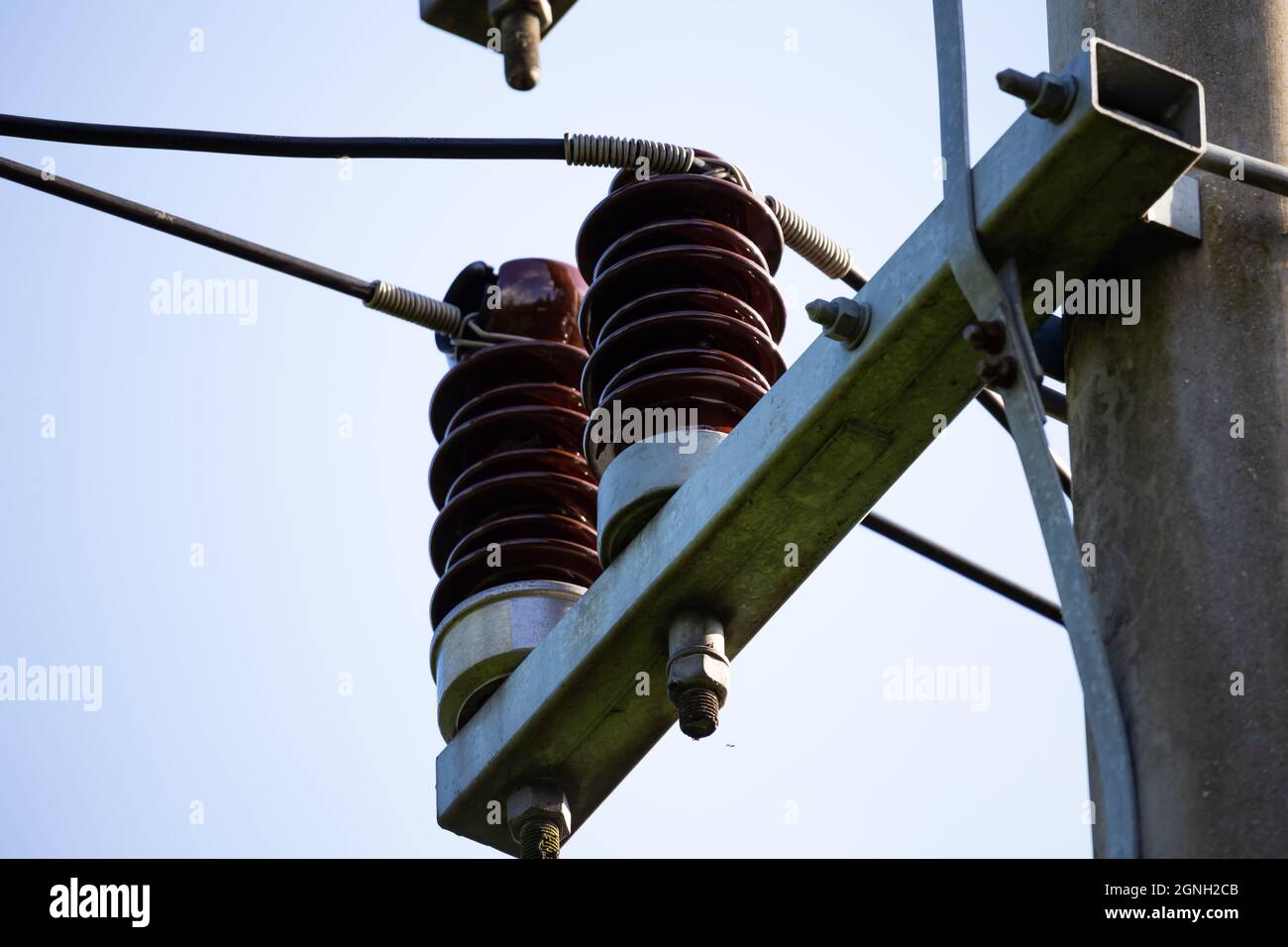 Ceramic insulators on low voltage pylons. Photo taken in good lighting conditions on a sunny day. Stock Photo