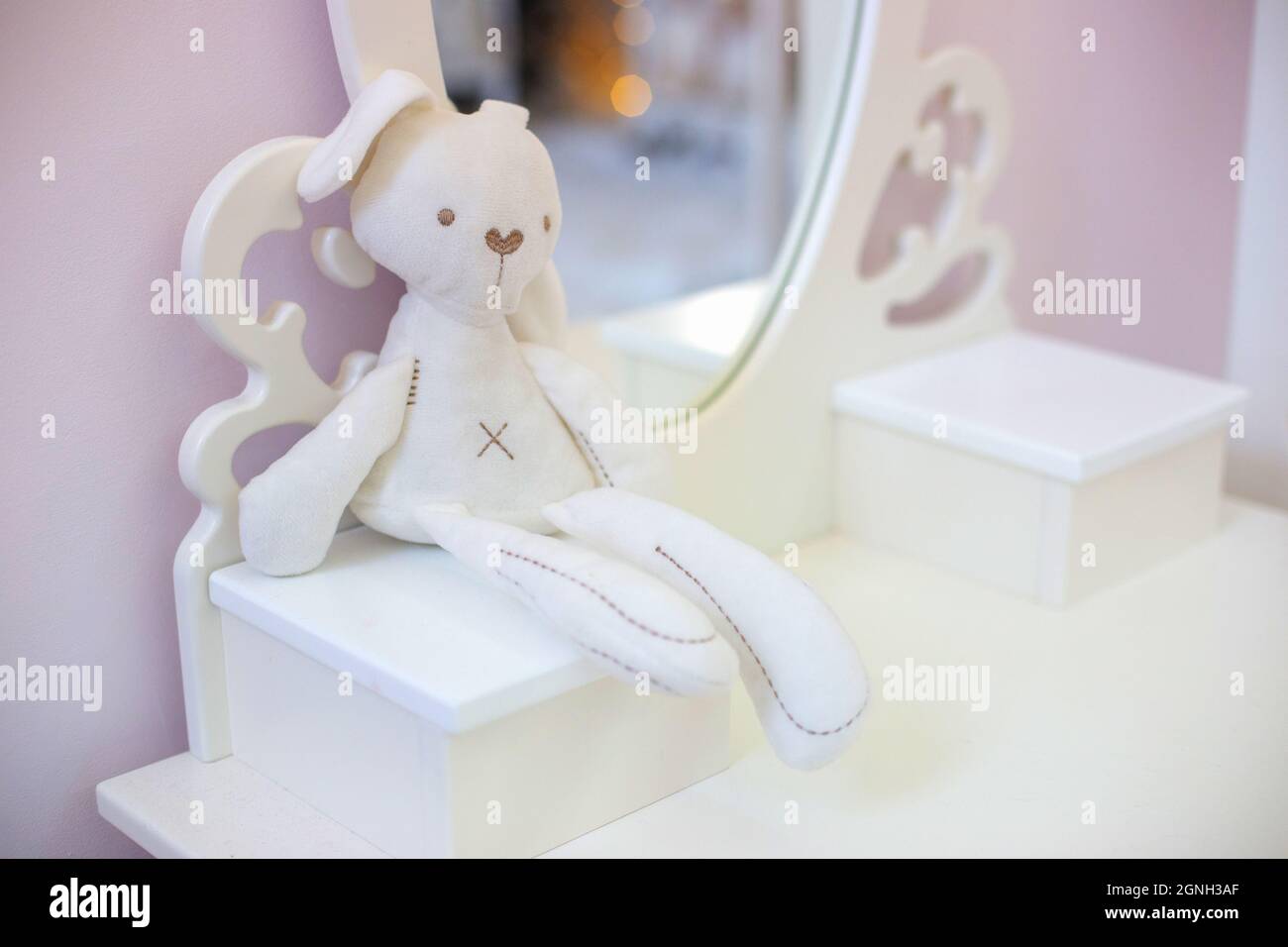 Cute white plush bunny toy, sits in a pink baby girl's room Stock Photo ...