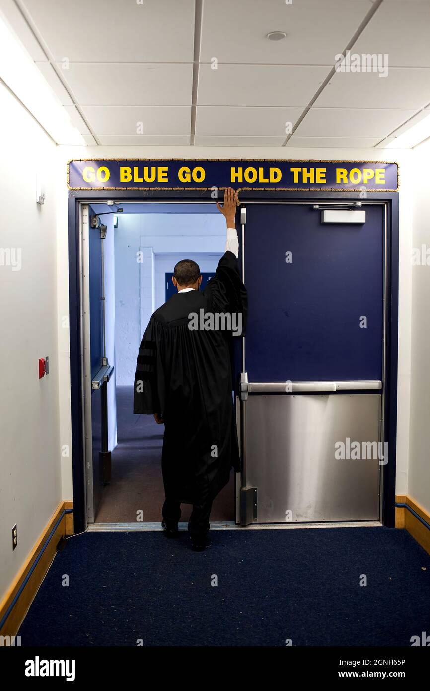 President Barack Obama touches the sign above the locker room door at Michigan Stadium, before giving the commencement address to University of Michigan graduates in Ann Arbor, Mich., May 1, 2010. (Official White House Photo by Pete Souza) This official White House photograph is being made available only for publication by news organizations and/or for personal use printing by the subject(s) of the photograph. The photograph may not be manipulated in any way and may not be used in commercial or political materials, advertisements, emails, products, promotions that in any way suggests approval Stock Photo