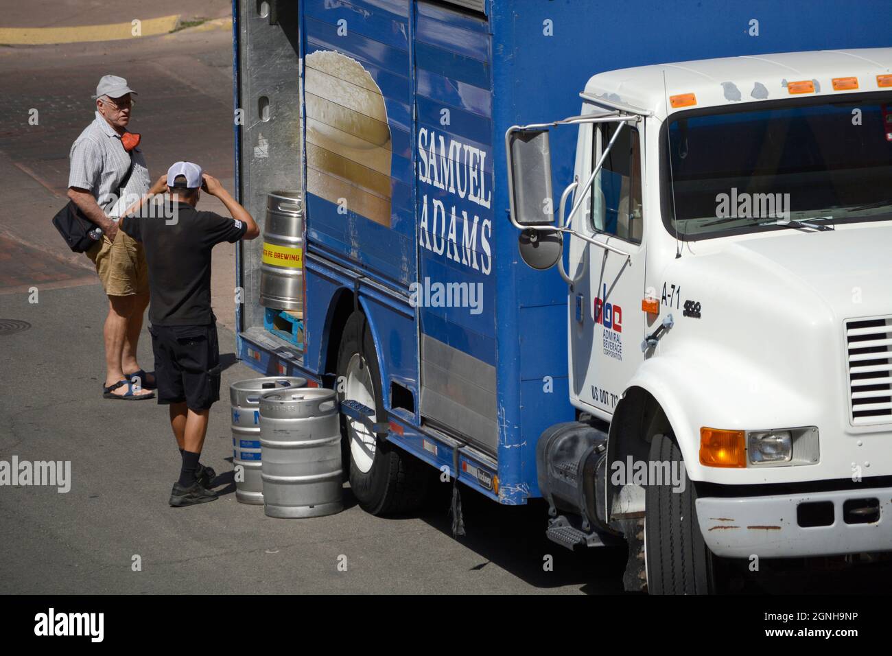 A beer deliveryman unloads kegs of beer to be delivered to a restaurant