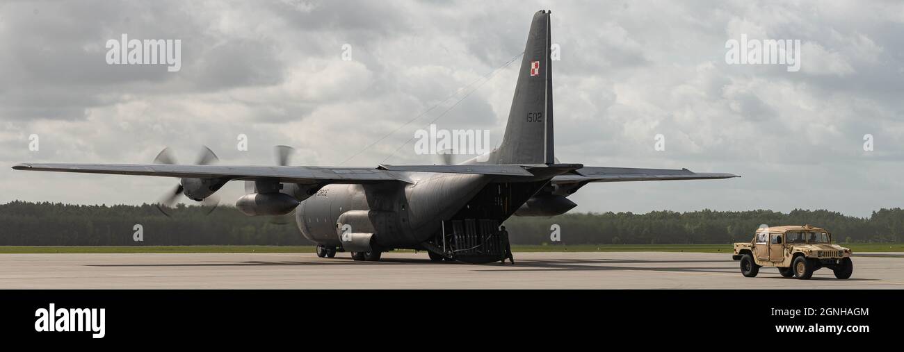 A humvee is loaded onto a Polish air force C-130E Hercules aircraft and then rapidly unloaded as part of a rodeo event at Powidz, Poland, Sept. 24, 2021 during Aviation Rotation Detachment 21-4. The rodeo contains a series of events between Polish and American service members creating friendly competition and increasing interoperability. (U.S. Air Force photo by Airman Edgar Grimaldo) Stock Photo