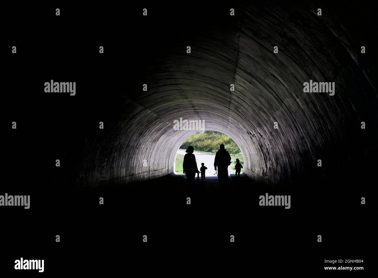 Silhouette of the family with light at the end of the tunnel in a public park Stock Photo