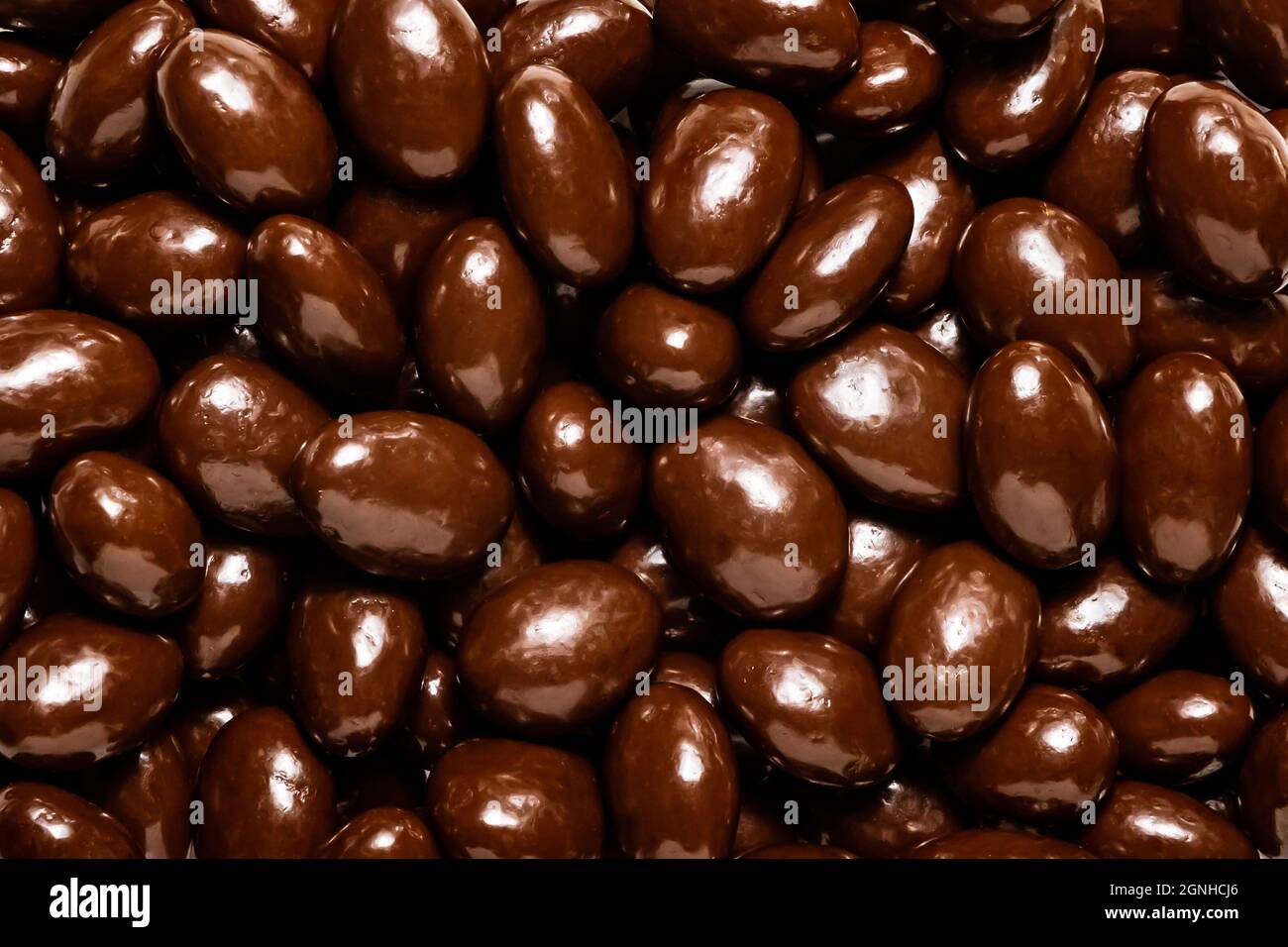 Dark chocolate covered almonds, isolated Stock Photo Alamy