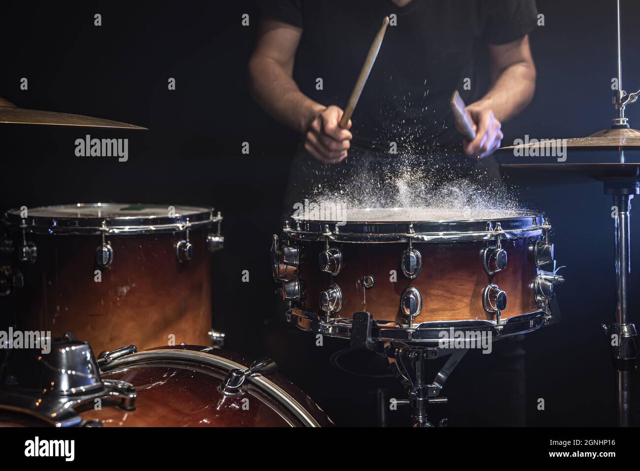 A male drummer plays snare drum with drumsticks in a dark room Stock ...