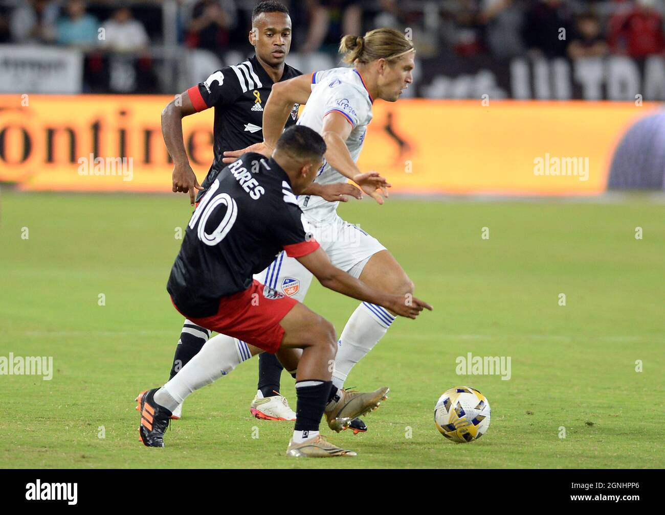 Washington, USA. 25th Sep, 2021. FC Cincinnati defender Jhon Espinoza (14)  moves the ball between D.C. United midfielder Edison Flores (10) and D.C.  United forward Ola Kamara (9), back, in the first
