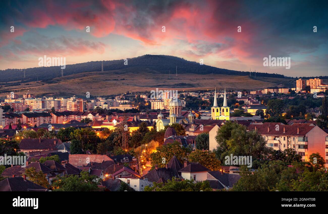 Captivating evening cityscape of Hunedoara. Fantastic summer sunset in Transylvania, Romania, Europe. Traveling concept background. Stock Photo