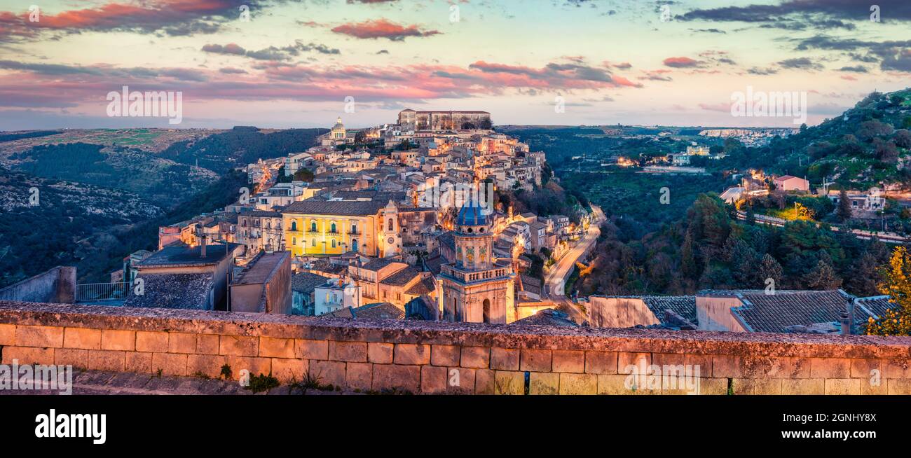 Panoramic spring cityscape of Ragusa town with Palazzo Cosentini and Duomo di San Giorgio church on background. Colorful sunset in Sicily, Italy, Euro Stock Photo