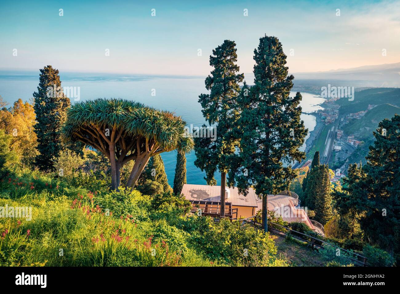 Stunning morning view of Taormina Giardini della Villa Comunale city park, Sicily, Itale, Europe. Sunny spring seascape of Mediterranean sea. Travelin Stock Photo