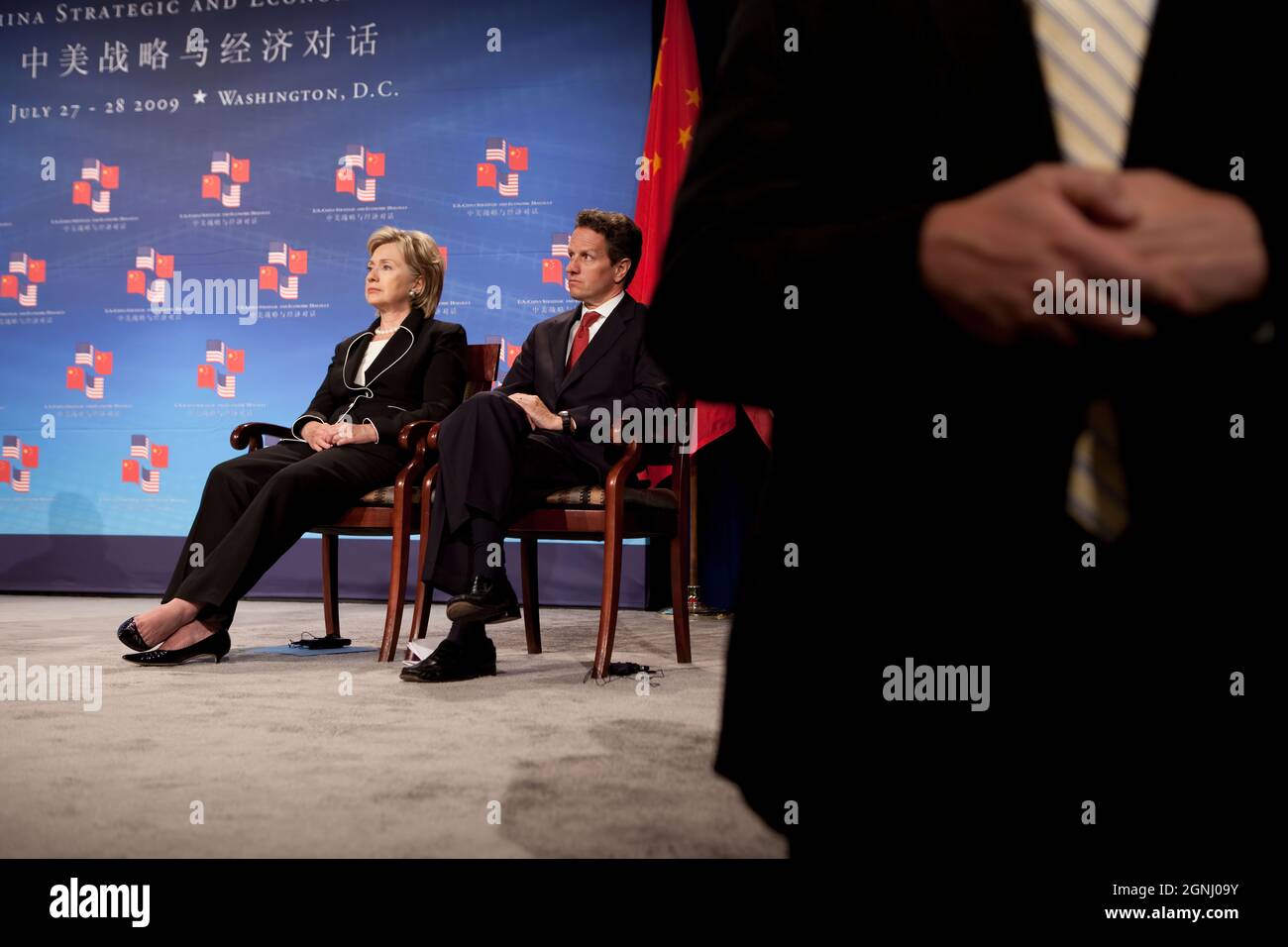 Secretary of State Hillary Clinton and Treasury Secretary Timothy Geithner look on as President Barack Obama addresses the opening session of the first U.S.-China Strategic and Economic Dialogue at the Ronald Reagan Building and International Trade Center in Washington on Monday, July 27, 2009.   (Official White House Photo by Pete Souza)  This official White House photograph is being made available for publication by news organizations and/or for personal use printing by the subject(s) of the photograph. The photograph may not be manipulated in any way or used in materials, advertisements, pr Stock Photo