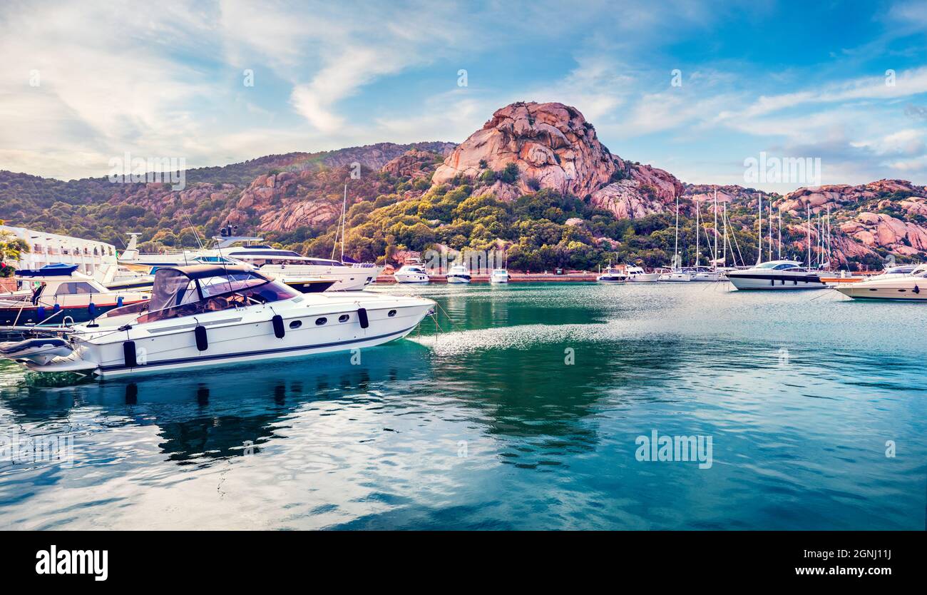 Splendid summer view of Poltu Quatu port with luxury yacht and motorboat. Stunning morning scene of Sardinia island, Italy, Europe. Bright Mediterrane Stock Photo