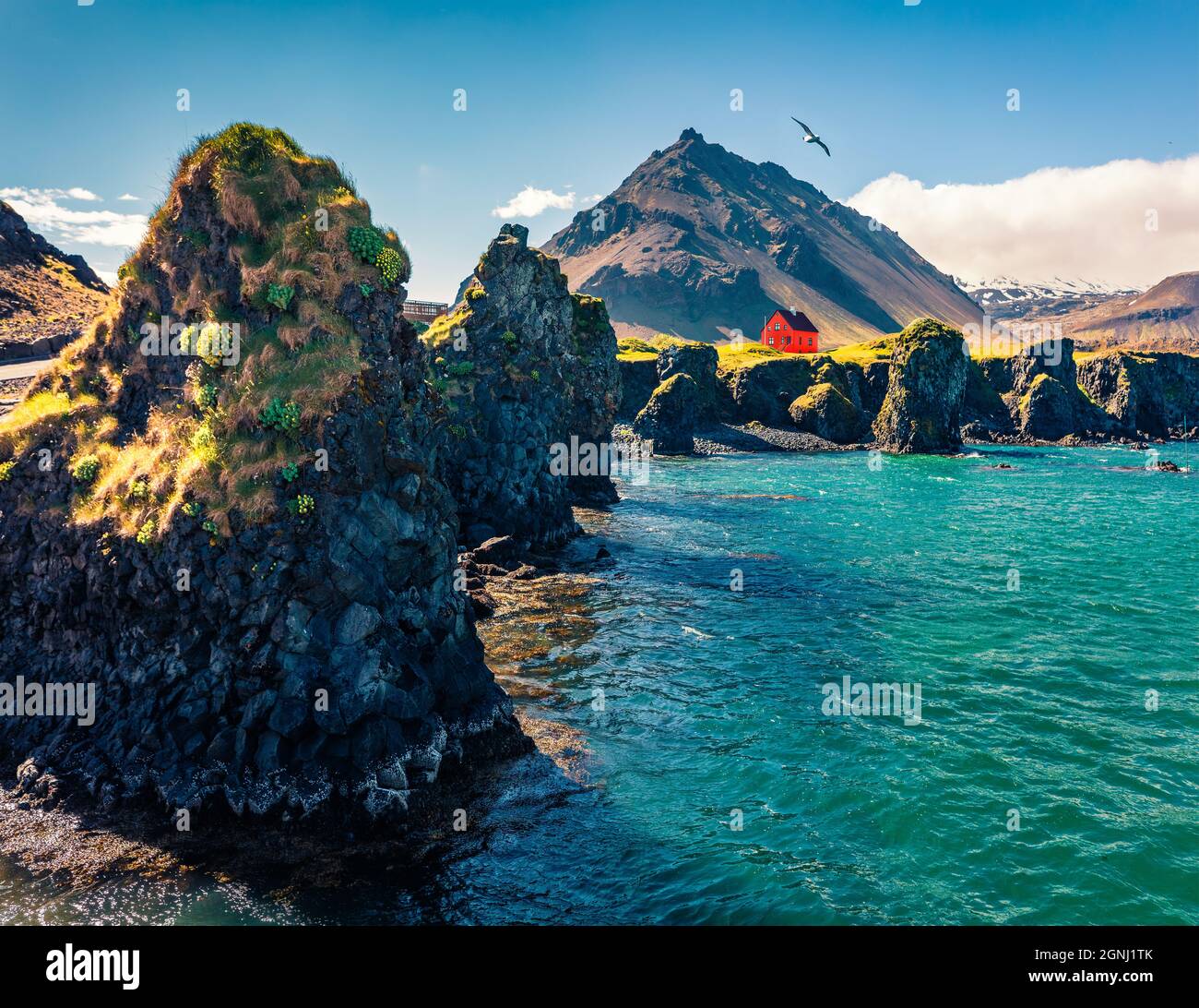 Sunny summer view of small fishing village at the foot of Mt. Stapafell
