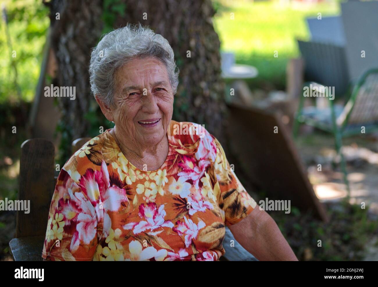 Portrait of senior woman sitting in nature Stock Photo