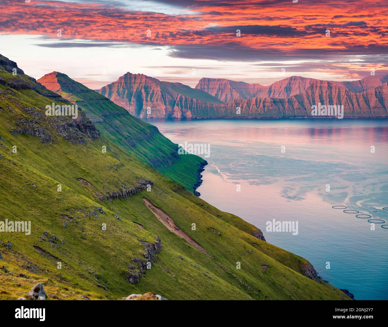 Exciting summer sunset on Faroe Islands, Denmark, Europe. Last sunlight glowing mountain ridge. Beauty of nature concept background. Stock Photo