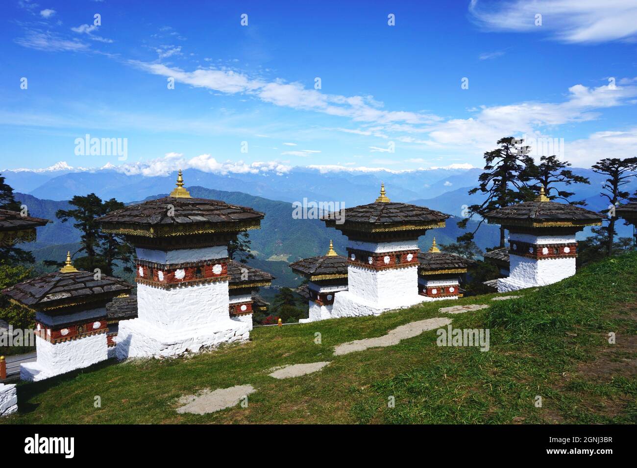 View of several of the Druk Wangyal Chortens at Bhutan’s Dochula Pass, between Thimphu and Punakha, with the snow-covered Himalaya mountains beyond Stock Photo