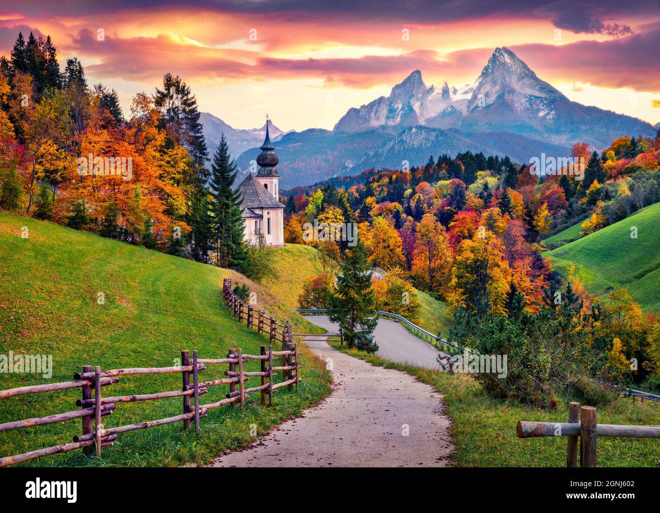 Iconic picture of Bavaria with Maria Gern church with Hochkalter peak on background. Fantastic autumn sunrise in Alps. Superb evening landscape of Ger Stock Photo