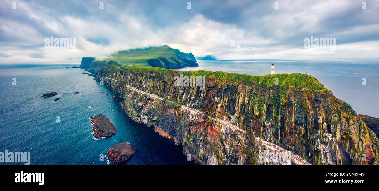 Panoramic view from flying drone of Mykines island with old lighthouse. Gloomy summer scene of Faroe Islands, Denmark, Europe. Stunning seascape of At Stock Photo