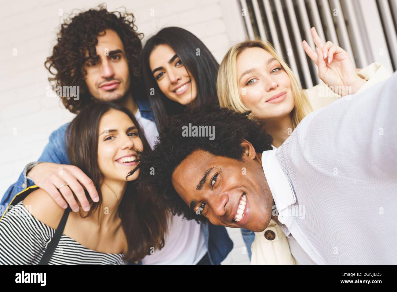 Multi-ethnic group of friends taking a selfie together while having fun ...