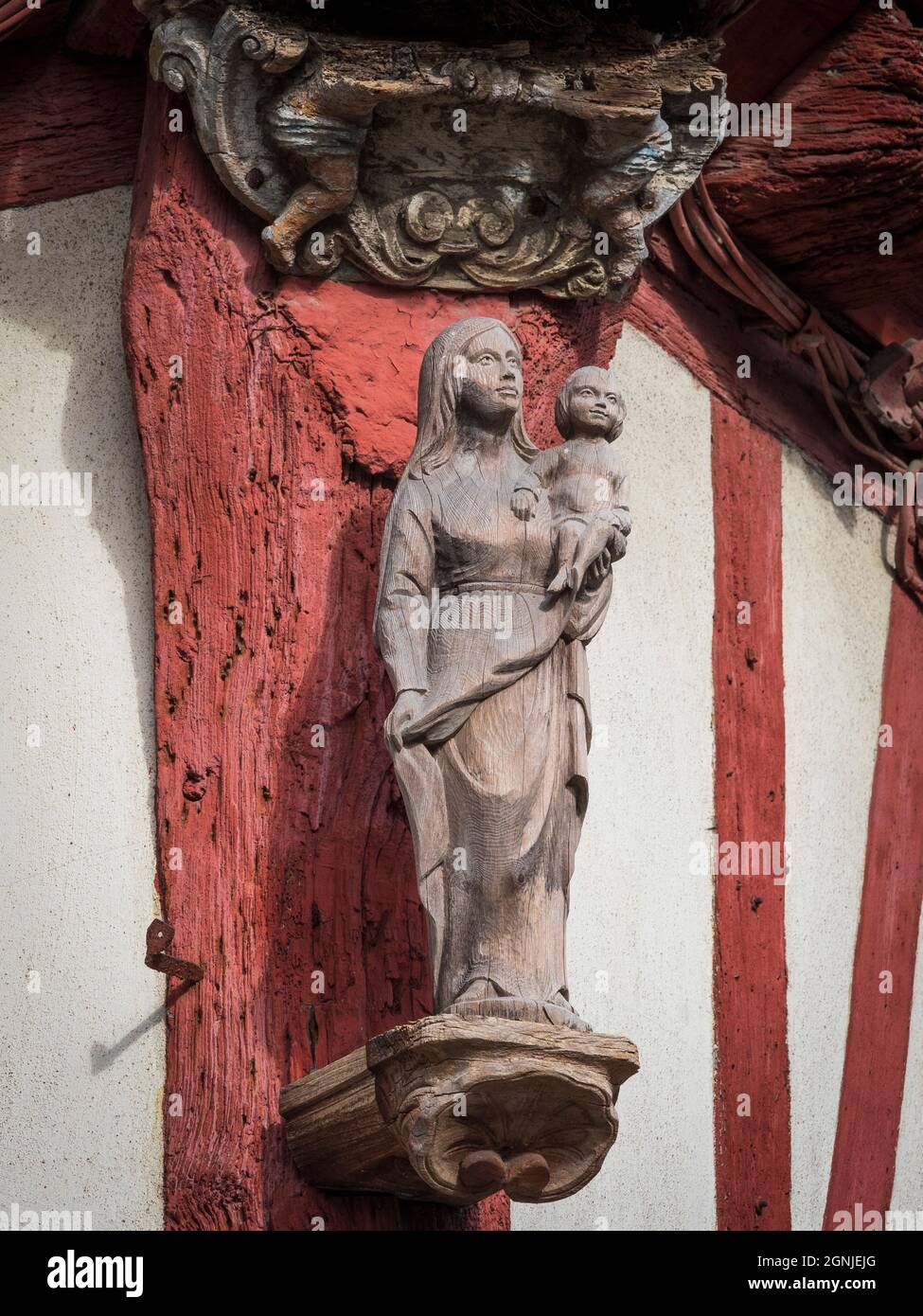 Madonna and Child,  Corner wooden sculpture, house at corner of Saint Nicholas and Fountain streets, Vannes, Morbihan, Brittany, France. Stock Photo