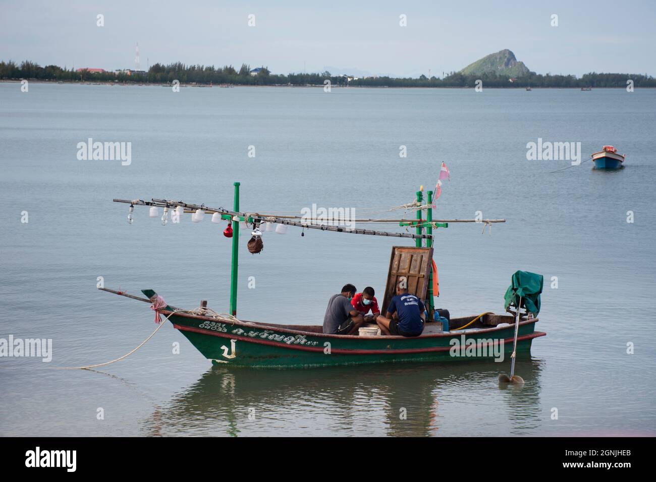 Fishermen maintenance and repair wooden fishing boat ship floating in sea  at Prachuap Bay in Gulf of thai and waiting catch fish and marine life on  Se Stock Photo - Alamy