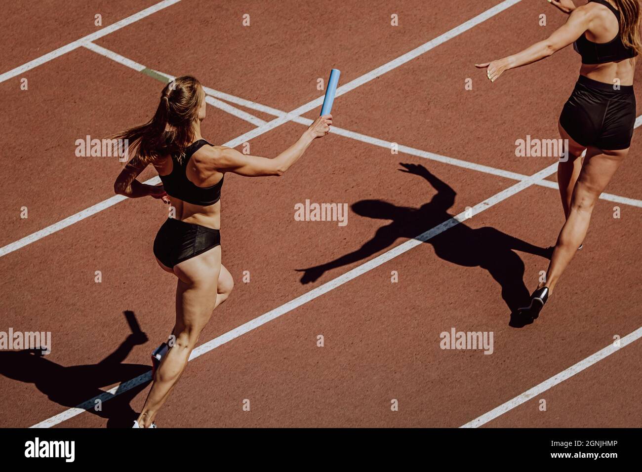 women relay race running for track and field competition Stock Photo