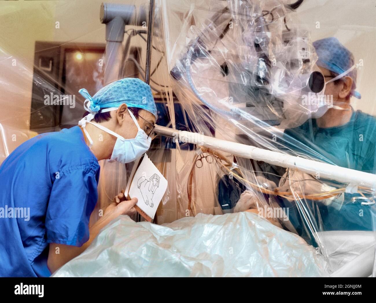 EDITORIAL USE ONLY: Hospital operation to perform microsurgery for brain tumour removal whilst the woman patient is awake and communicating with anoth Stock Photo