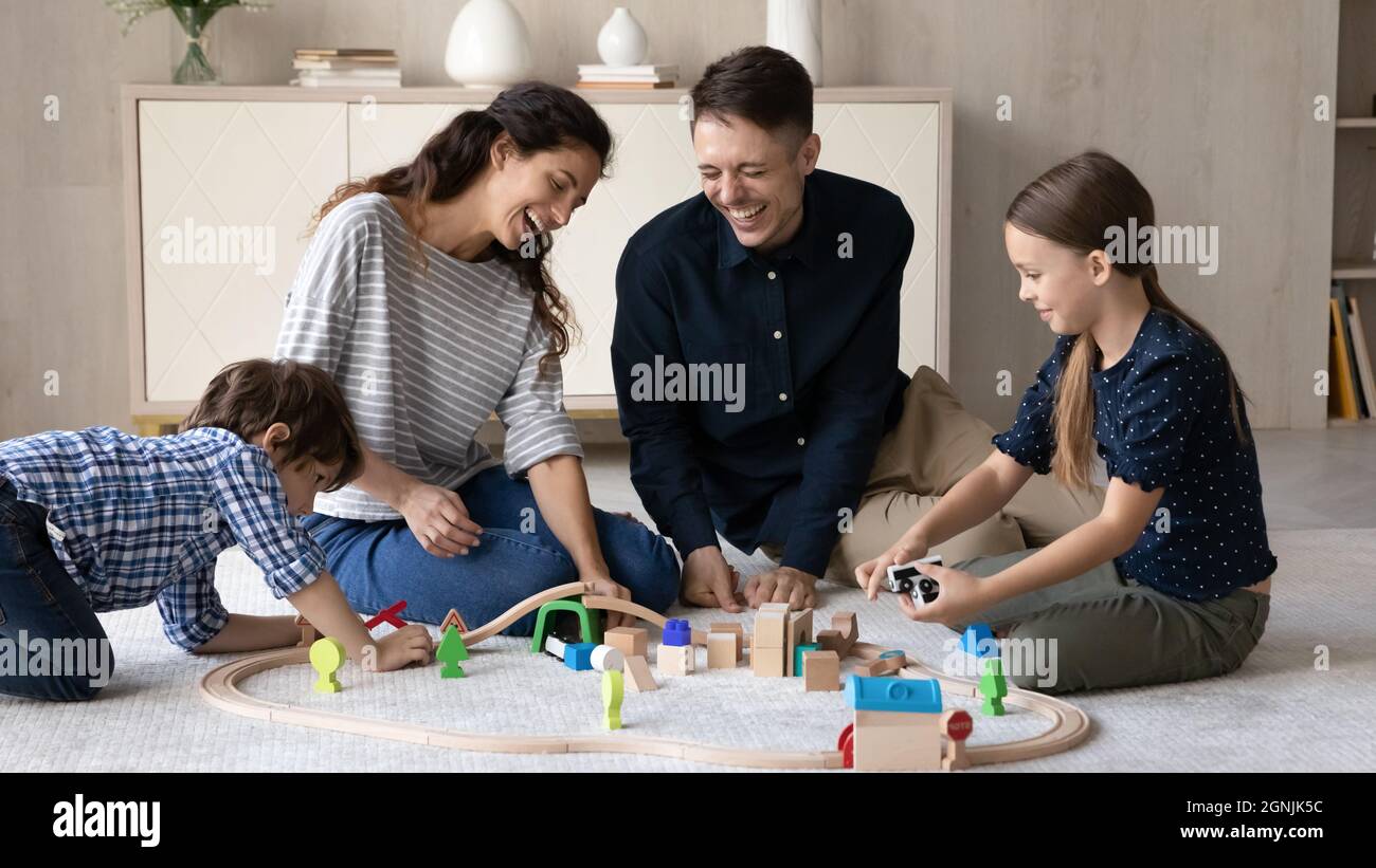 Happy young parents playing toys with children Stock Photo - Alamy