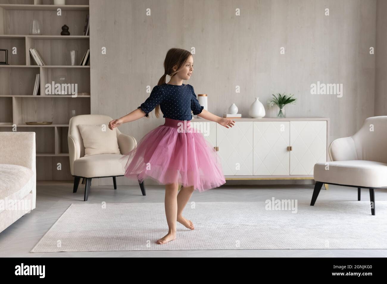 Joyful little girl dancing in modern living room Stock Photo Alamy