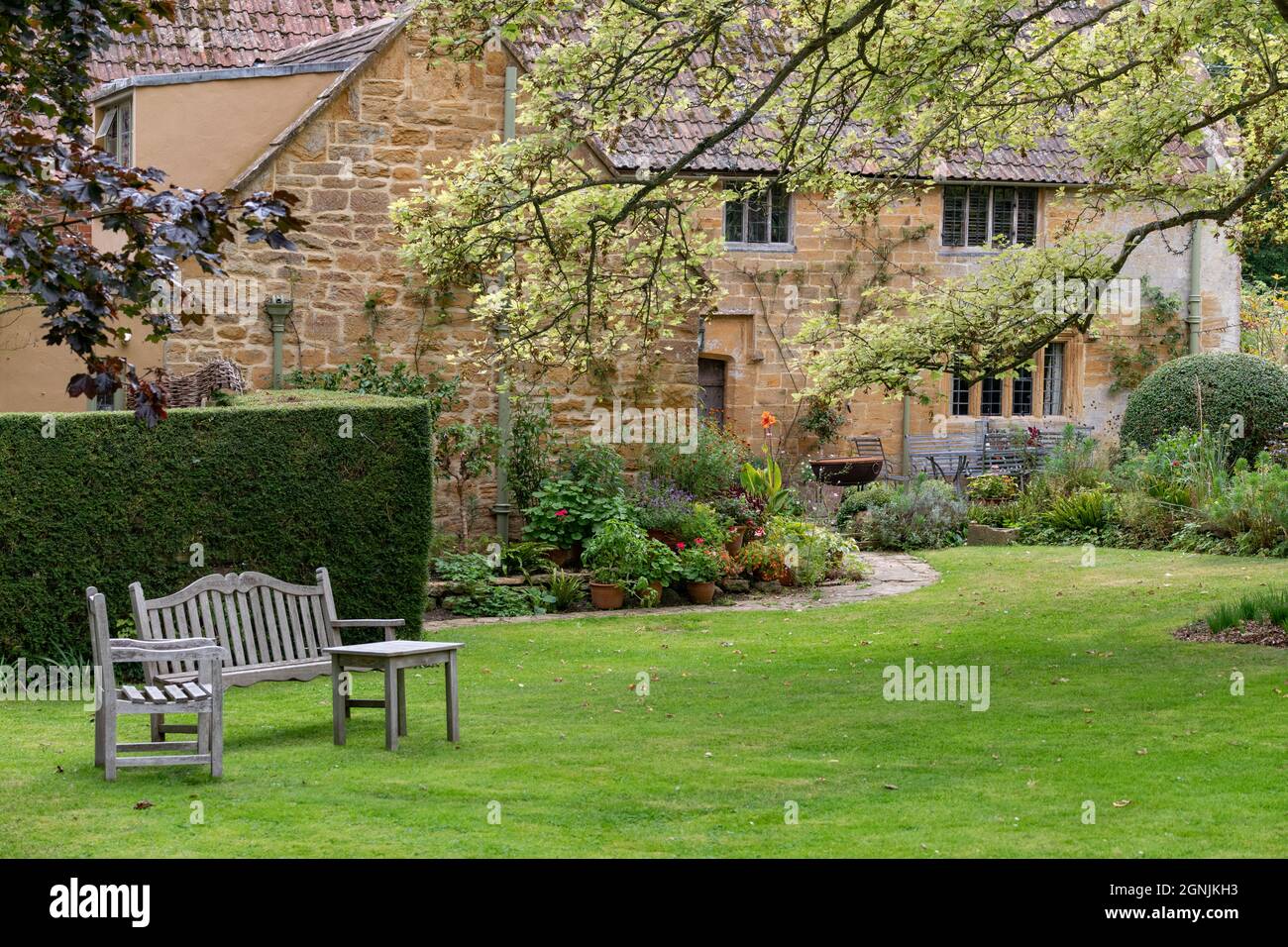 old stone cottage village  with wooden garden seat Stock Photo