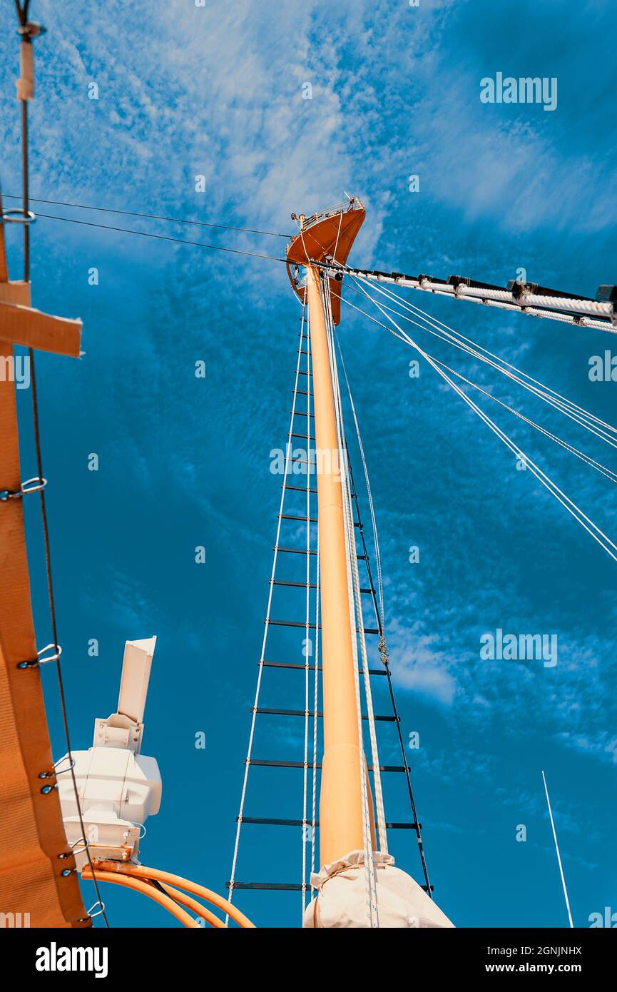 Details of a historic wooden sailboat against a cloudless sky. A pulley