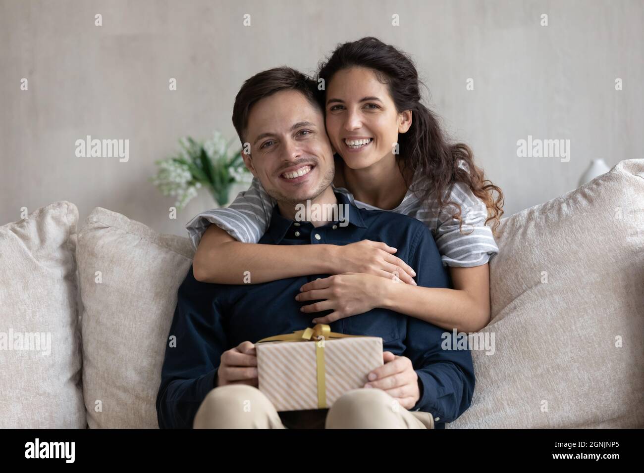 Portrait of affectionate young couple with wrapped present. Stock Photo