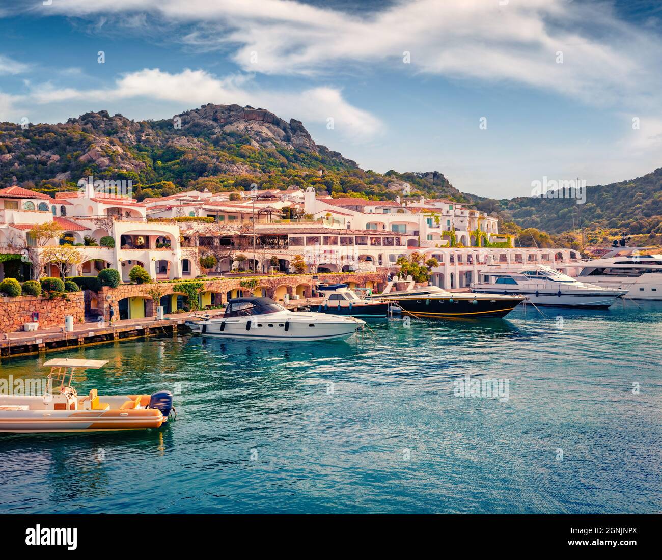 Adorable summer view of Poltu Quatu port with luxury yacht and motorboat. Stunning morning scene of Sardinia island, Italy, Europe. Bright Mediterrane Stock Photo