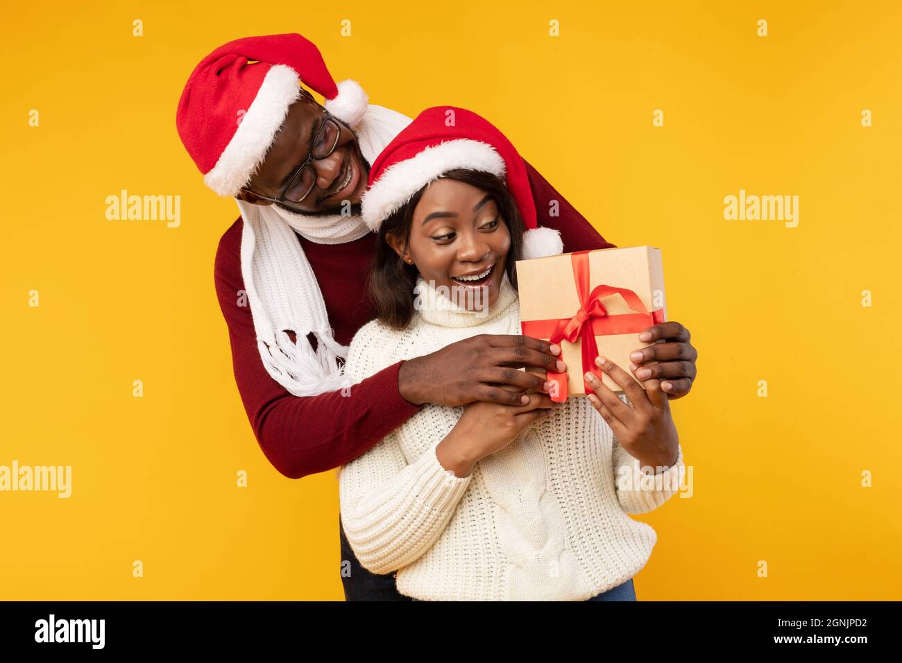 African American Husband Surprising Wife Giving Christmas Gift, Yellow ...