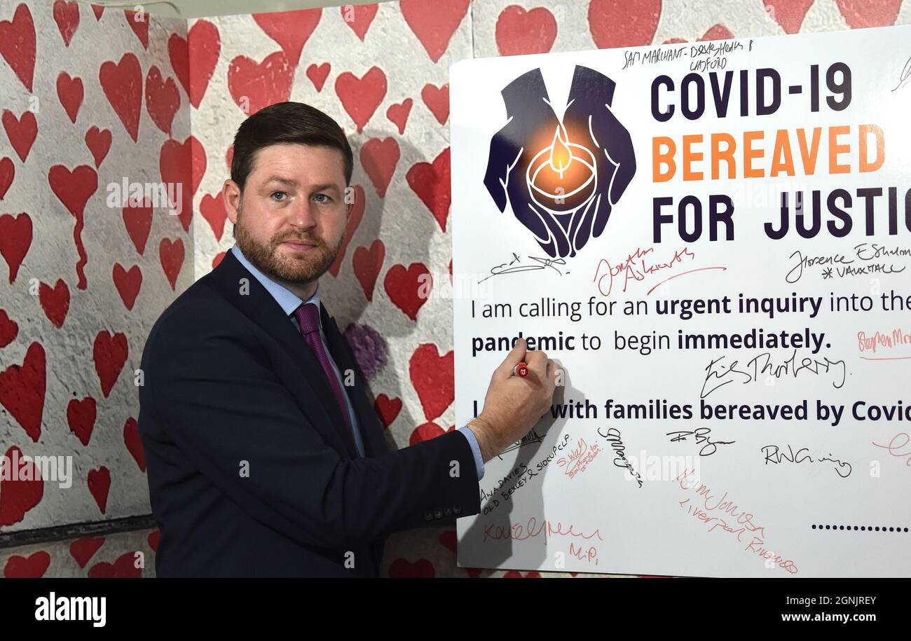 Brighton UK 26th September 2021 - Jim McMahon Shadow Secretary of State for Transport signs a COVID-19 Bereaved families For Justice banner  at the Labour Party Conference being held in the Brighton Centre  : Credit Simon Dack / Alamy Live News Stock Photo