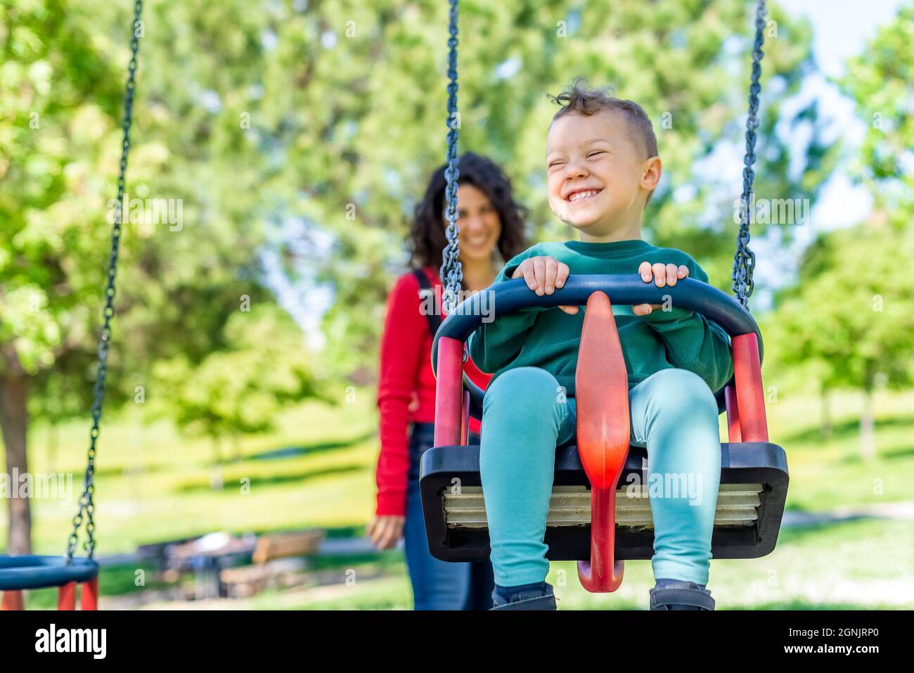 happy Child playing on outdoor playground with his mom. Kids play on ...