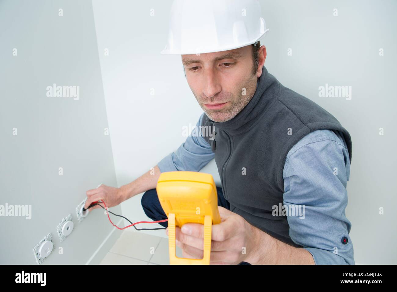 electrician testing plug socket with multimeter Stock Photo Alamy